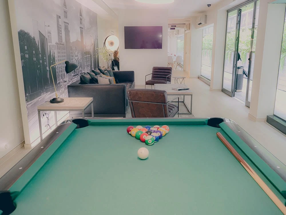 Sala de juegos con mesa de billar y mural de Barcelona en Aparthotel BCN Montjuïc