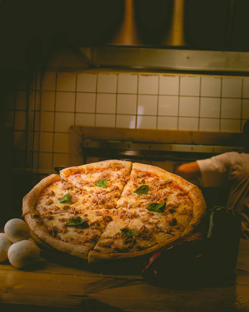 Pizza de atún y cebolla recién horneada en la cocina de Mimmos Pizza