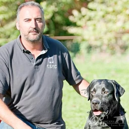 Francesc, criador de Ronçana, junto a un labrador retriever negro